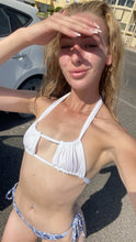 Load image into Gallery viewer, Woman in a white bikini standing outdoors on a sunny day.