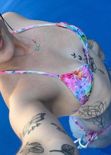 Load image into Gallery viewer, Person wearing a colorful bikini with tattoos visible on a blue background