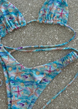 Load image into Gallery viewer, Blue bikini set with starfish pattern on a concrete surface