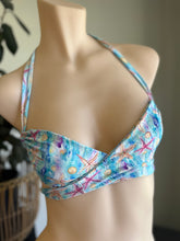 Load image into Gallery viewer, Colorful bikini top with starfish pattern on a mannequin against a neutral background
