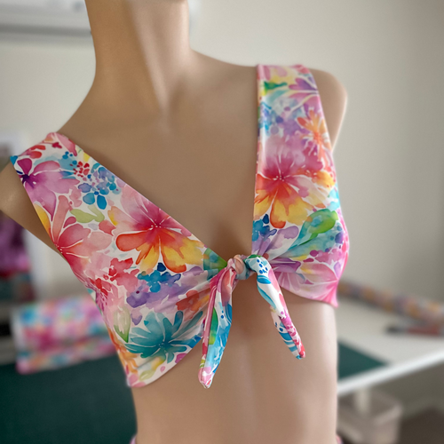 Colorful floral bikini on a mannequin against a neutral background