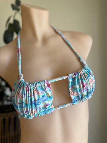 Floral bikini top on a mannequin against a neutral background