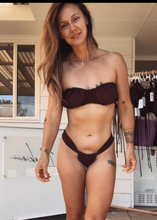 Load image into Gallery viewer, Woman wearing a brown bikini standing outdoors with a store in the background
